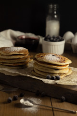 Stack of oat pancakes with black currant, and a sprinkling of powdered sugar