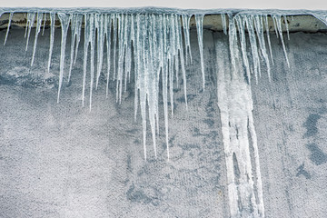 Hanging Icicles on The Building Wall During Frosty Winter Season.