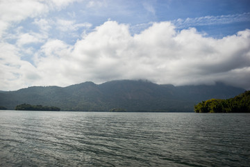 A scenic view of mountains, trees and clouds