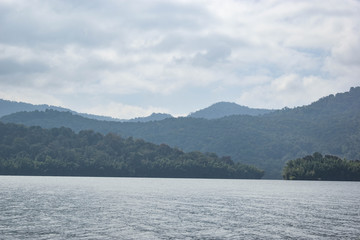 A scenic view of mountains, trees and clouds
