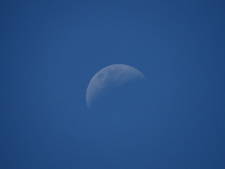 a moon in a blue afternoon