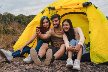 diverse people of caucasian and asian friends having fun together traveling and camping at natural park in summer
