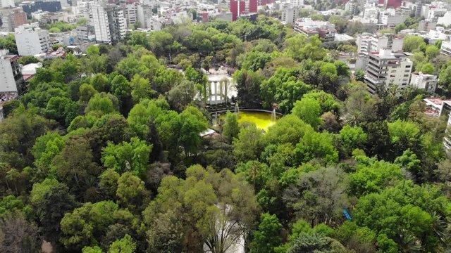 Aerial view of Parque M&eacute;xico in Colonia Condesa, drone flying forward very slowly.