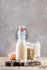 Soy milk and soy bean on gray table. Non-dairy milk concept. Vegan drink. Copy space