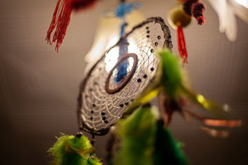 Dreamcatcher in the light of the lamp. The mystical doctrine of the idnians. Fractal weaving amulets. Belief in evil spirits abducting dreams. Remedy for insomnia. National sign. Home decoration.