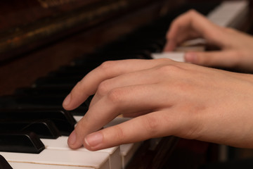 Fototapeta premium Hands of a girl playing the piano close-up