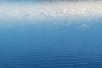 Water surface of the lake with light ripples from the wind