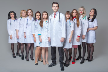 Full length portrait of an attractive male doctor staying at the head of group of doctors
