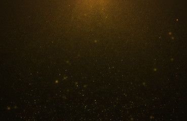 Glowing golden abstract bokeh glitter lights background of flickering gold particles and light flare