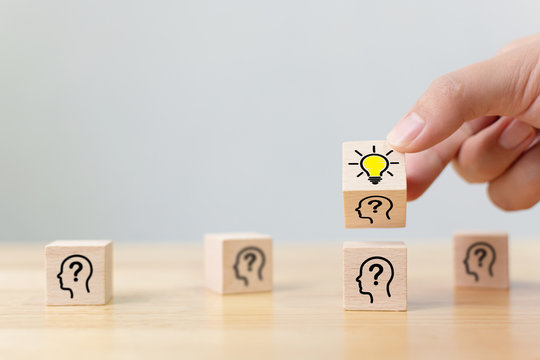 Concept creative idea and innovation. Hand flip over wooden cube block with head human symbol and light bulb icon