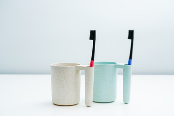 A couple toothbrush mug set on a white table