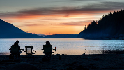 Garibaldi provincial park. Unrecognizable people by the lake with turquoise water at sunset. Snow mountain at the background. Hikers on the trail. British Columbia, Canada. © Daniel Avram