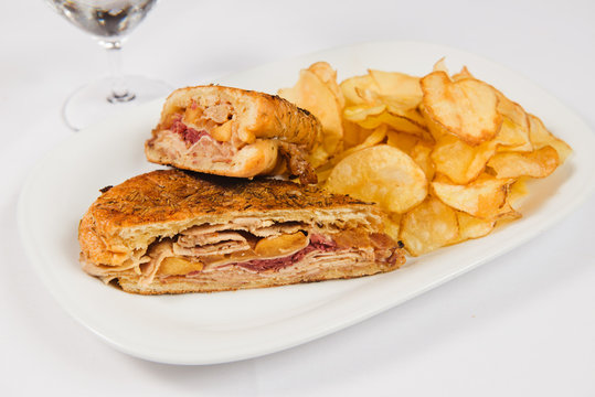 Ruben sandwich with potato chips on white