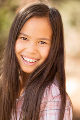 Portrait of a young asian girl smiling outside.