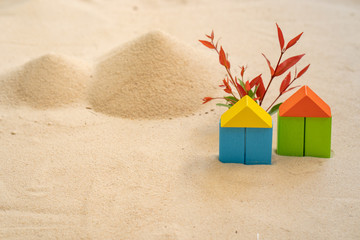 Naklejka premium concept of colored wooden houses on the sand.