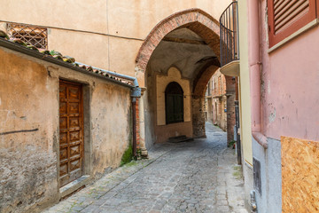 Fototapeta na wymiar Italy, Sicily, Palermo Province, Castelbuono. Archway over cobblestone street in the town of Castelbuono.