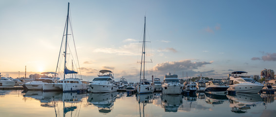 Beautiful clear sunset in the sea harbor with moored yachts.