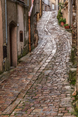 Fototapeta na wymiar Italy, Sicily, Palermo Province, Geraci Siculo. Winding narrow cobblestone street in the town of Geraci Siculo.