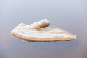Chunks of white ice from the detached ice float on the river in an ice drift in the springtime.