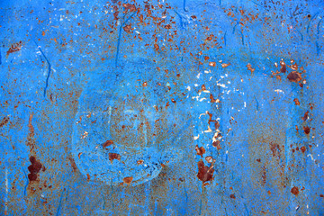 Abstract background of peeling white paint on a blue wall, rust on a cold wall