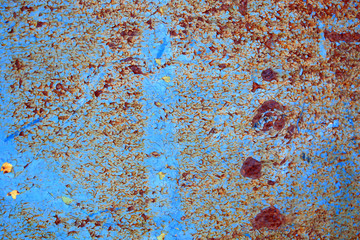 Abstract background of peeling white paint on a blue wall, rust on a cold wall