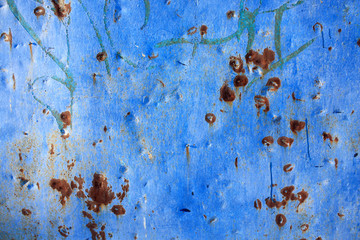Abstract background of peeling white paint on a blue wall, rust on a cold wall