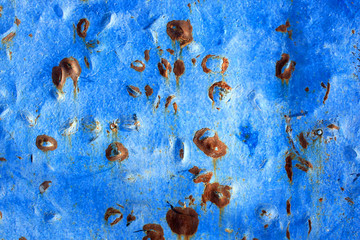 Abstract background of peeling white paint on a blue wall, rust on a cold wall