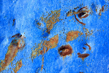 Abstract background of peeling white paint on a blue wall, rust on a cold wall