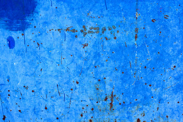 Abstract background of peeling white paint on a blue wall, rust on a cold wall