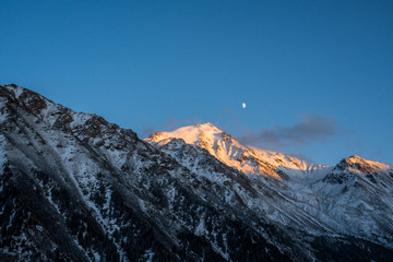 Fototapeta na wymiar Reflection of moon by mountains in winter
