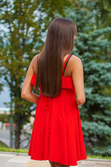 Naklejka premium Back view close up portrait young beautiful brunette woman in red dress