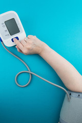 Measurement of blood pressure using a medical electronic automatic tonometer. A blood pressure monitor measures the pressure on a woman