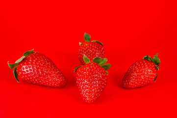 Strawberry ripe and juicy, very tasty and healthy, shot large on a bright red background