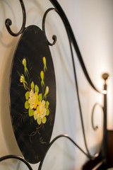 Vertical shot of a flower painted on a bed metal railing