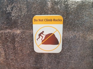 do not climb rocks sign on grey rock
