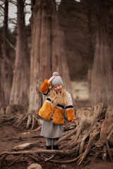 a baby walks by a cypress lake in the middle of tall cypress trees