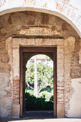 Vertical Shot of a Door in a Historic Spanish Mission Church with a Resurgam Plaque over the top
