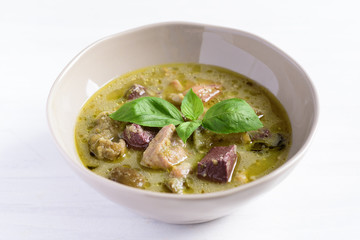 Thai green curry chicken in a bowl on white table, Thai food