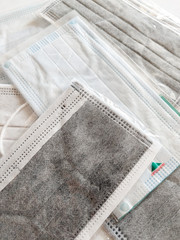 A bunch of disposable surgical face masks on a white background