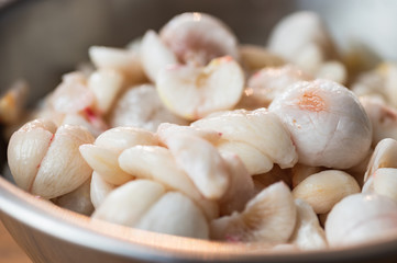 Mangosteen flesh out of its shell in a metal bowl.