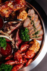 Mixed grilled meat platter. Assorted delicious grilled meat with vegetable. Mixed grilled meat with pepper sauce and vegetables.