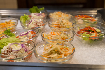 salads in bowls in the open kitchen of the restaurant are in a row
