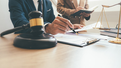 Judge gavel with Justice lawyers having team meeting at law firm background. Concepts of Law and...