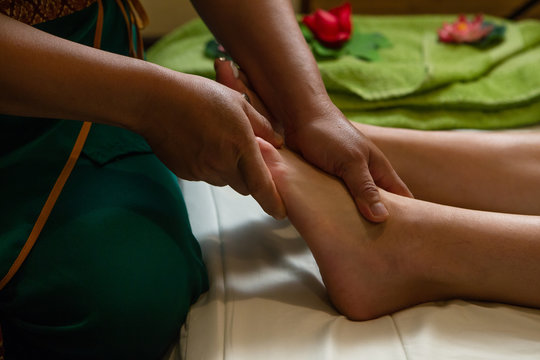 Foot massage.Masseuse massaging woman's foot. Professional therapist giving oil massage to a woman in spa