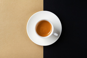 Obraz na płótnie Canvas Cup of coffee on gold black background. Minimalistic flat lay. Top view.