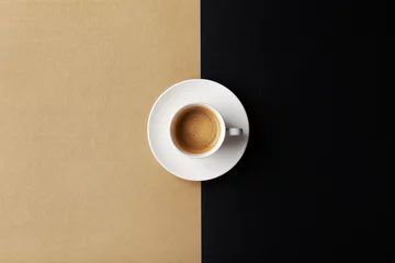 Foto op Plexiglas Cup of coffee on gold black background. Minimalistic flat lay. Top view. © juliasudnitskaya