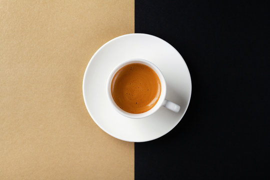 Cup of coffee on gold black background. Minimalistic flat lay. Top view.