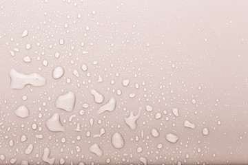 Drops of water on a color background. Selective focus. Beige. Toned