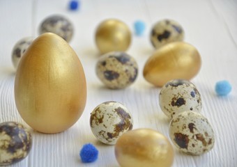 Easter.  eggs of gold and natural color on a light background.