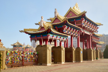 Naklejka premium Entrance in buddhist temple in the fog on a summer, spring or autumn day. Buddhism in Russia in Elista